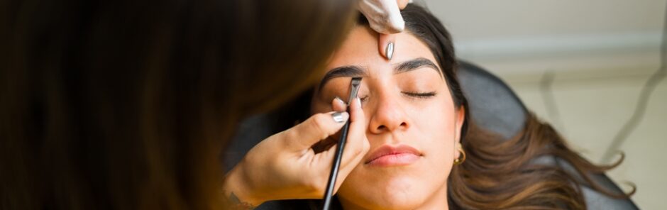 Client getting her brows done by a cosmetologist student