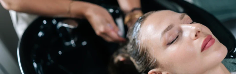 Hairstylist washing client’s hair