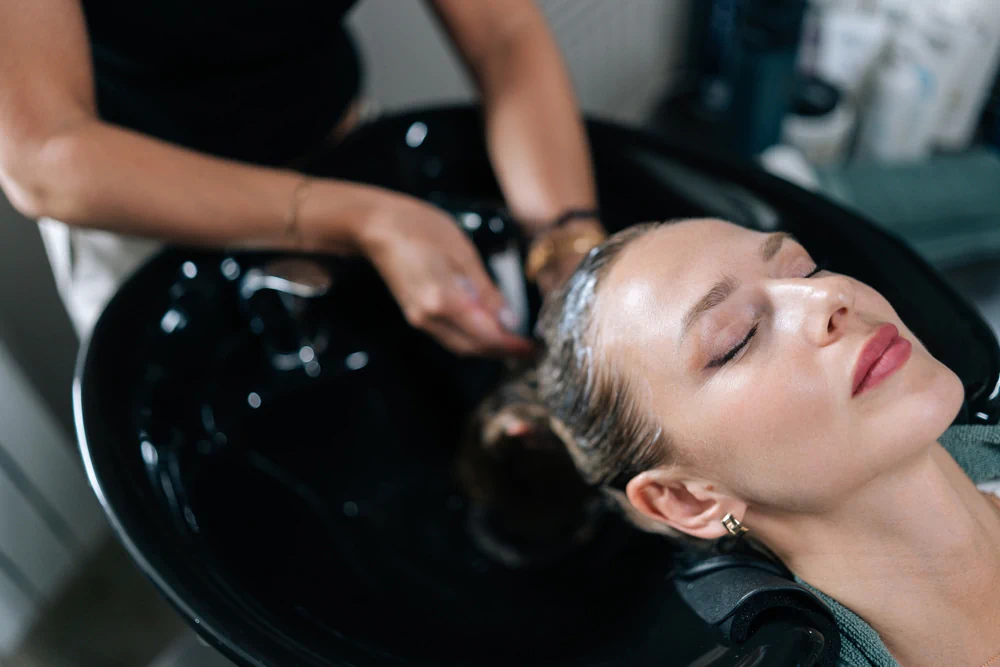 Hairstylist washing client’s hair