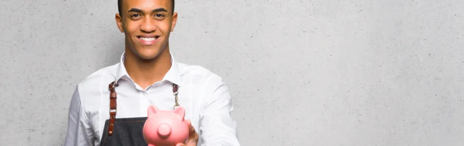 Young barber holding a piggy bank