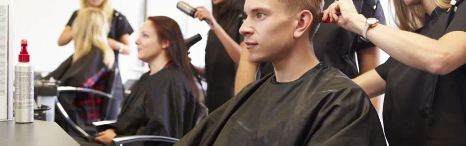 Cosmetology students working on a male client