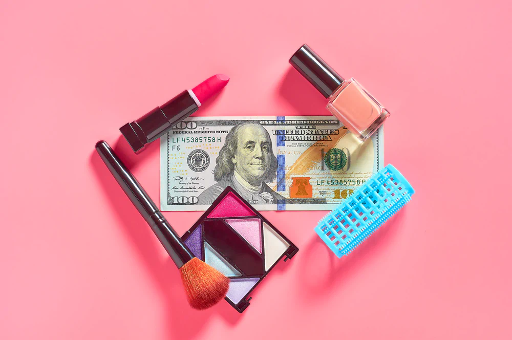 Makeup and brushes on top of a $100 dollar bill