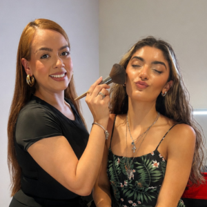 Cosmetology student practicing advanced hair styling techniques on a mannequin in a beauty school classroom.